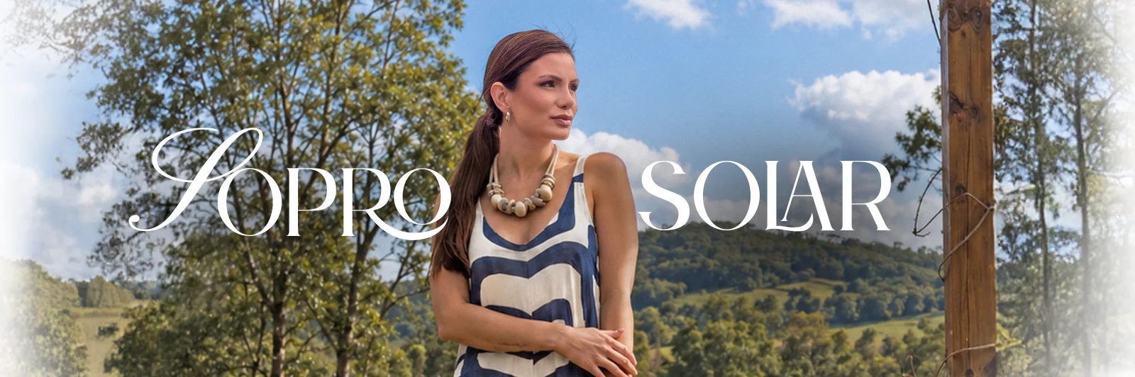 Campanha Sopro Solar: modelo de vestido azul e cru diante da serra, com o lettering da coleção